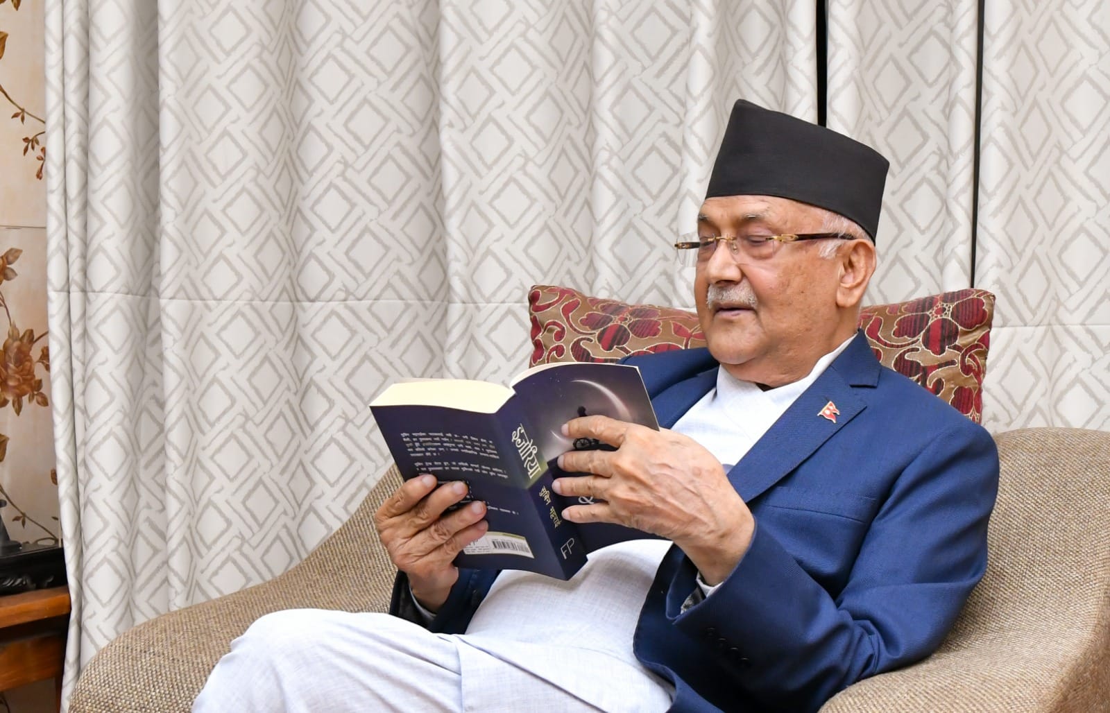 सुविन भट्टराईको इजोरिया उपन्यास पढ्दै ओली 