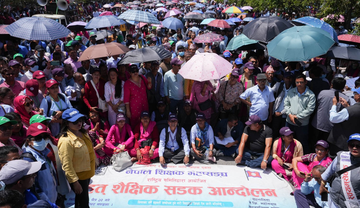 चर्को घाममा छाता ओढेर आन्दोलनमा शिक्षकहरू (तस्वीरहरू)